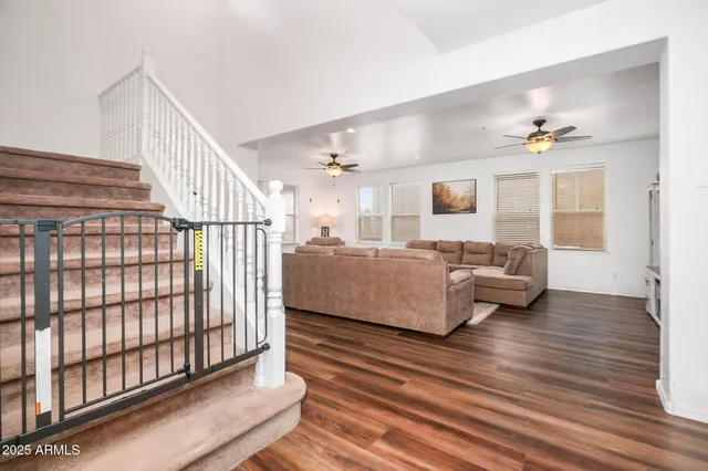 a living room with furniture and a ceiling fan
