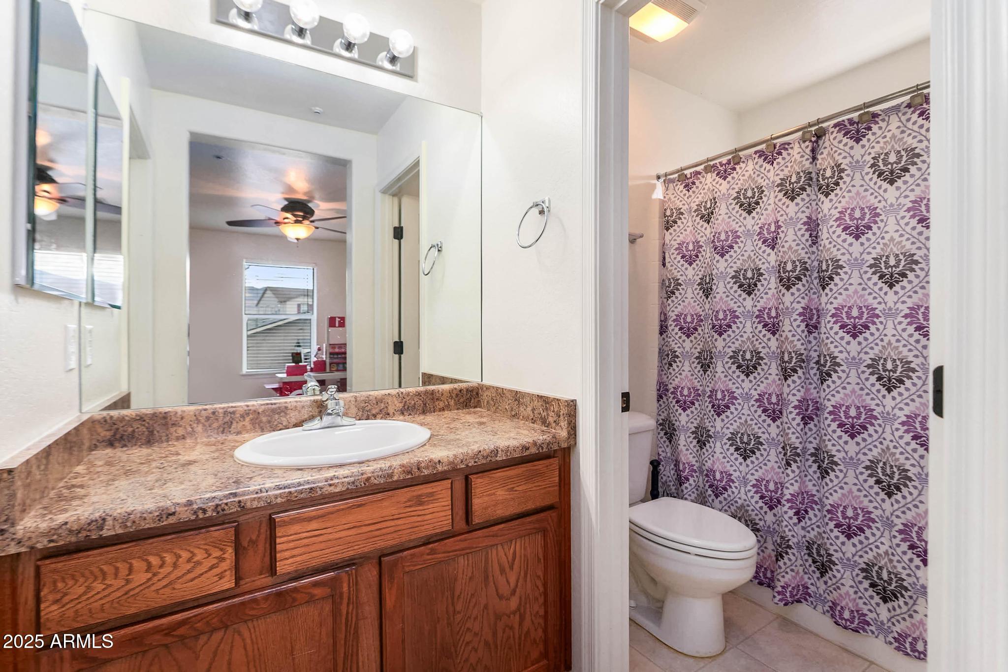 608 Bootleg Road Clarkdale, AZ 86324 - Photo 36 of 111 a bathroom with a granite countertop sink a toilet and a mirror