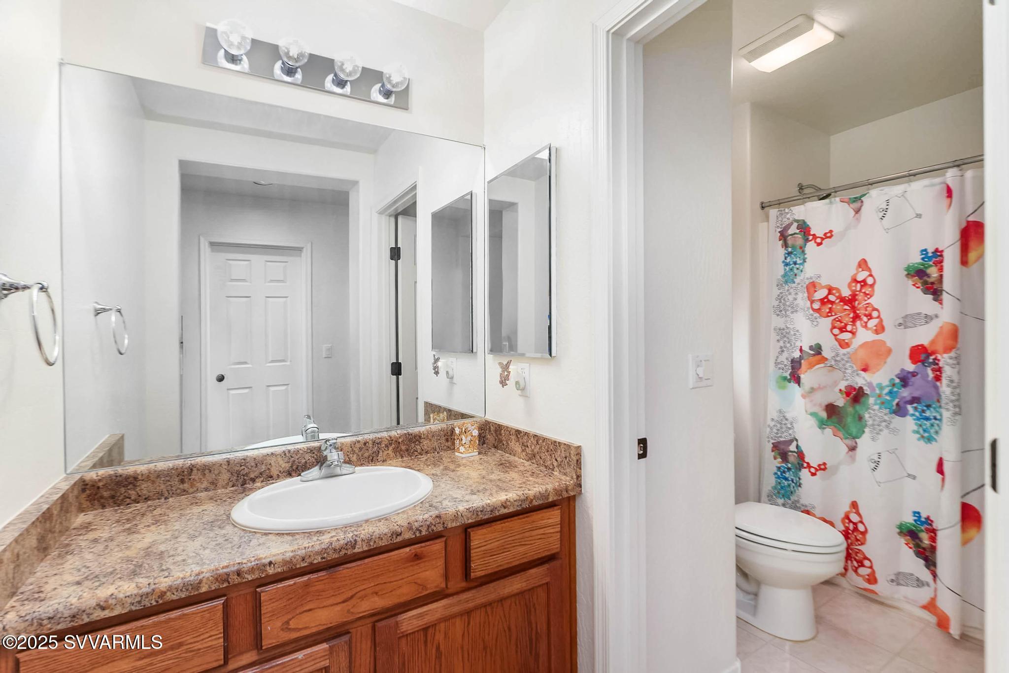 608 Bootleg Road Clarkdale, AZ 86324 - Photo 84 of 111 a bathroom with a granite countertop sink and a mirror with toilet