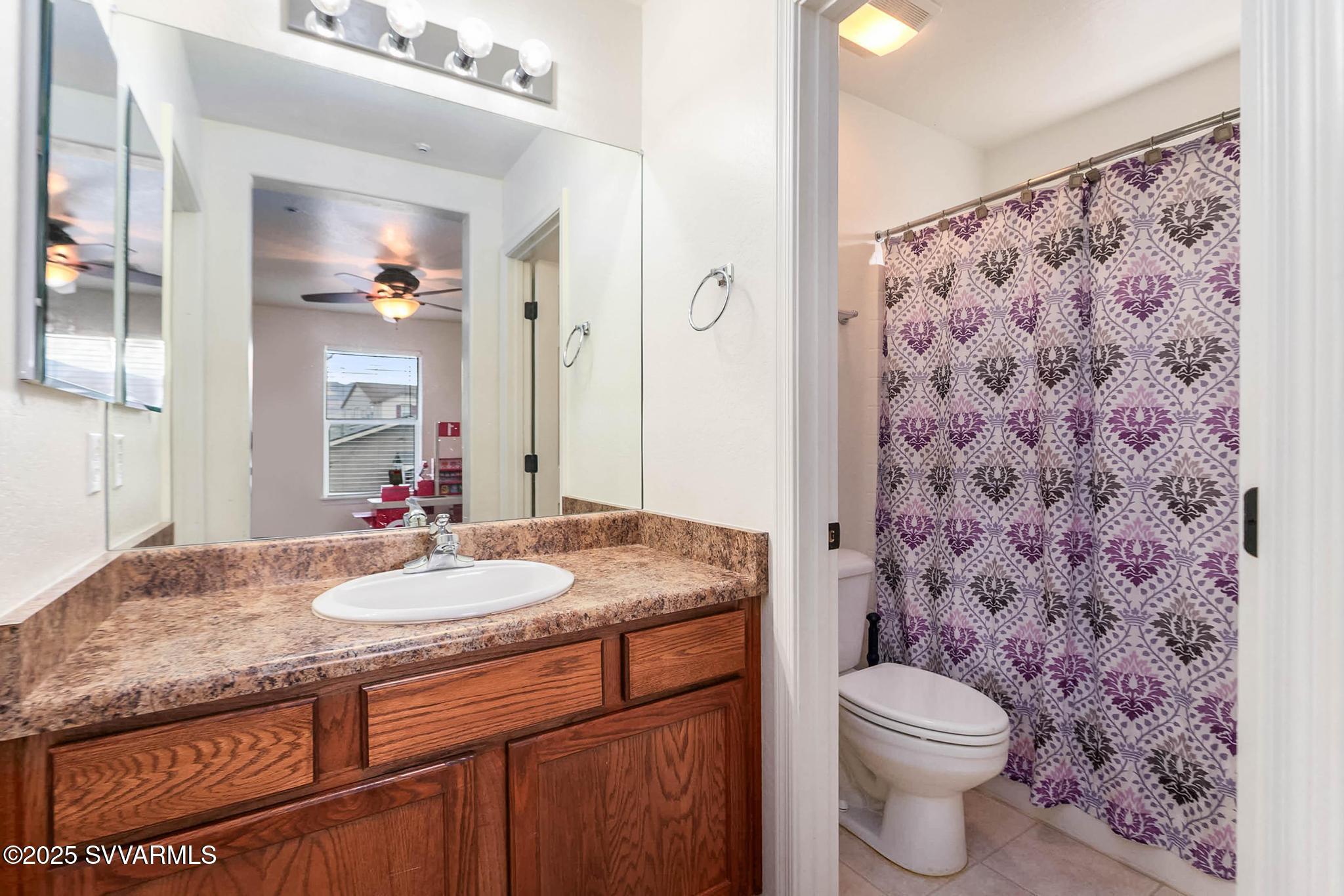 608 Bootleg Road Clarkdale, AZ 86324 - Photo 89 of 111 a bathroom with a granite countertop sink a toilet and a mirror