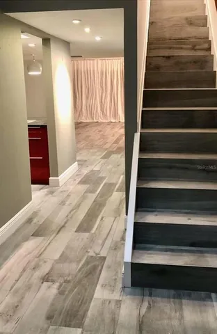 a view of a hallway with wooden floor and stairs