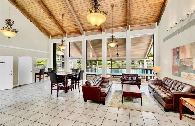 a dining room with furniture and large windows