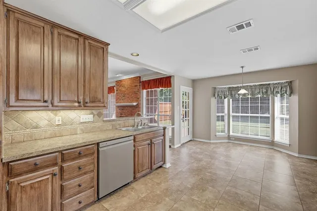 a view of a kitchen with granite countertop cabinets stainless steel appliances a sink and a large window