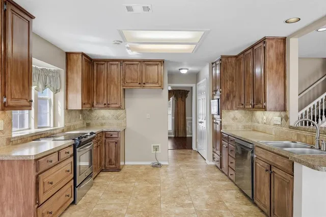 a kitchen with stainless steel appliances granite countertop a sink stove and refrigerator