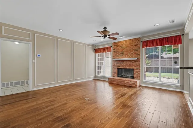 a view of empty room with wooden floor and fireplace
