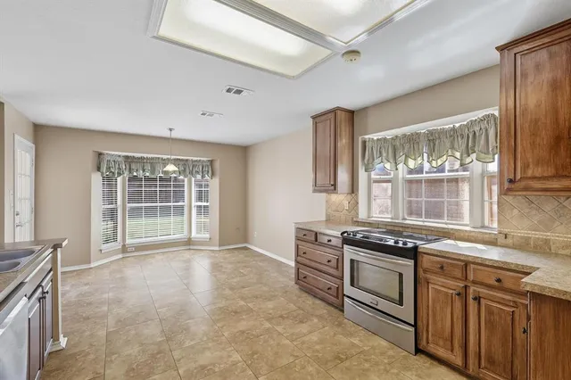 a kitchen with stainless steel appliances a stove a sink and a refrigerator