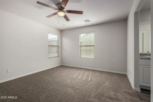 an empty room with windows and fan