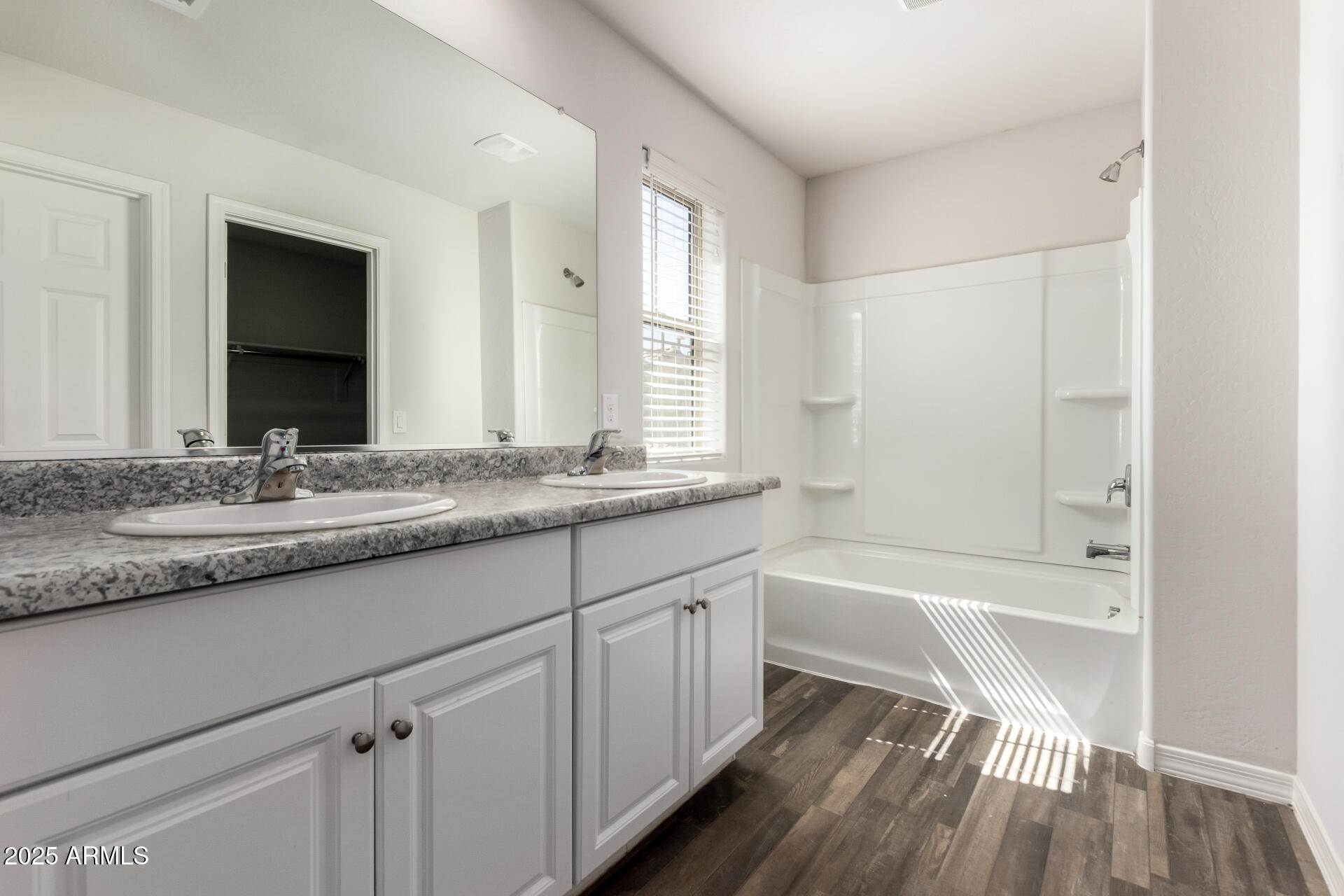 5464 Fulton Street Phoenix, AZ 85043 - Photo 21 of 31 a bathroom with a granite countertop sink a mirror and a bathtub