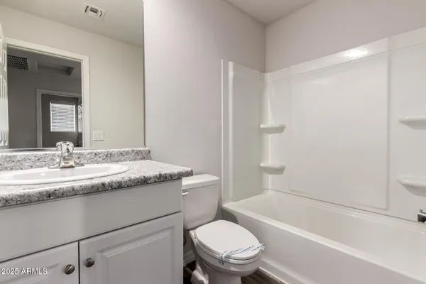 a bathroom with a granite countertop toilet a sink and a bathtub