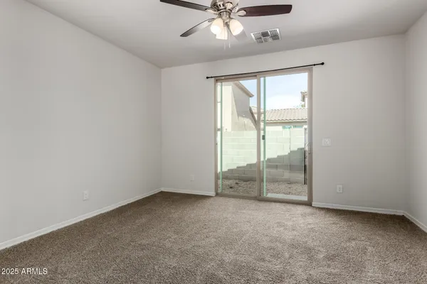 an empty room with chandelier fan