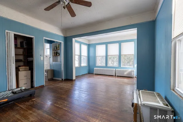 an empty room with wooden floor and windows