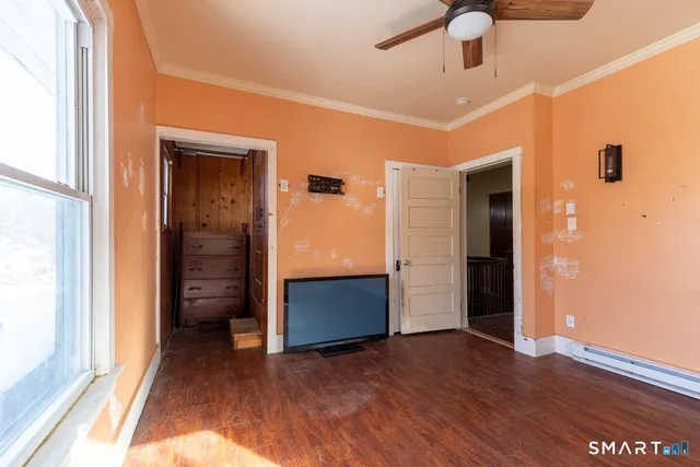 a view of empty room with wooden floor