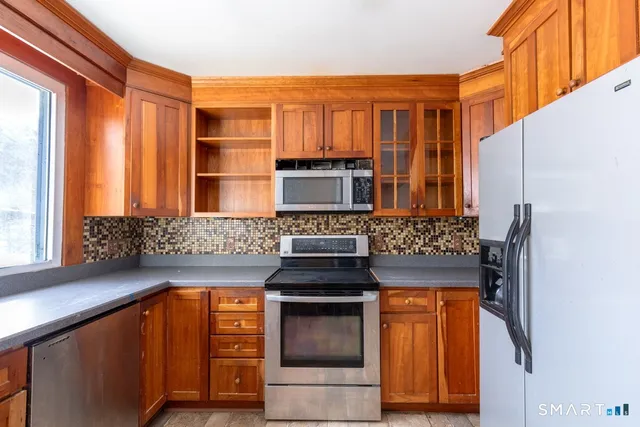 a kitchen with stainless steel appliances granite countertop a stove and a refrigerator
