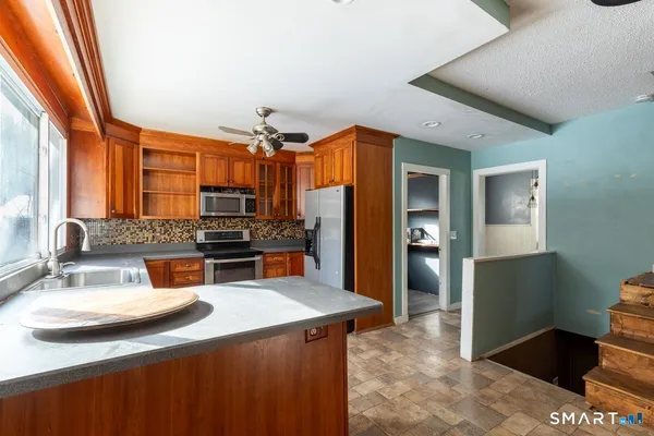 a kitchen with stainless steel appliances a sink stove and refrigerator