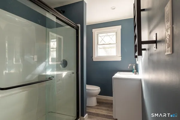 a bathroom with a toilet a sink and mirror