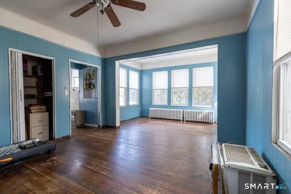 an empty room with wooden floor and windows