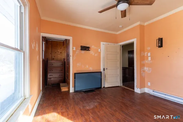 a view of empty room with wooden floor