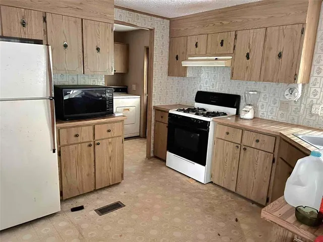 a kitchen with stainless steel appliances a stove a refrigerator sink and cabinets