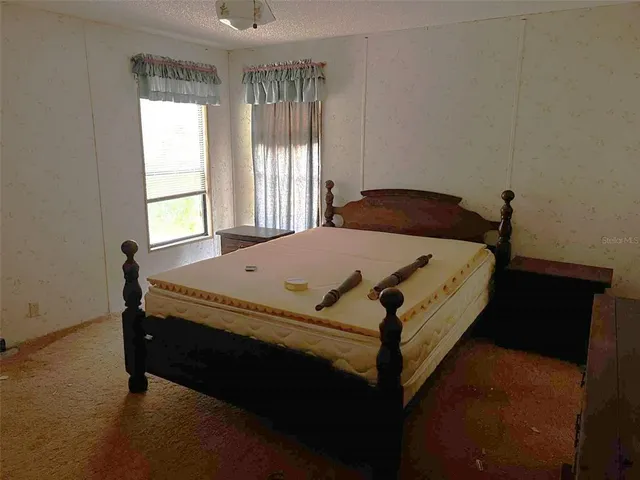 a bed sitting in a bedroom next to a window