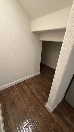 an empty room with windows and hardwood floor