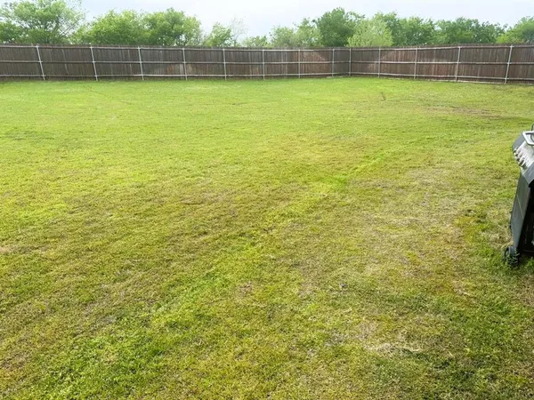 a view of a house with a big yard and large trees
