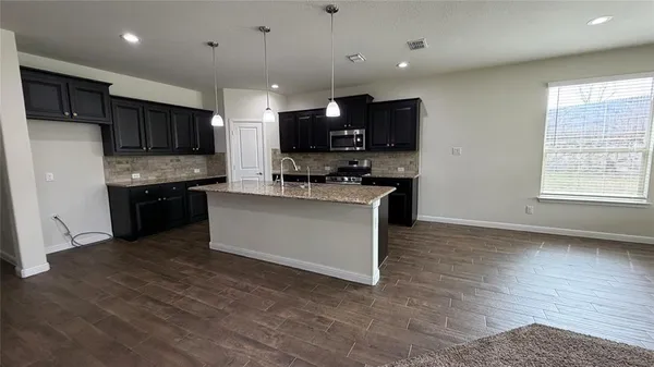 a kitchen with kitchen island a sink and a stove top oven