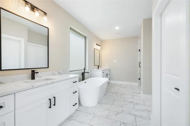 a bathroom with a double vanity sink a mirror and a bathtub