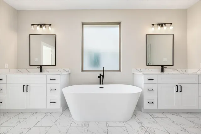 a bathroom with a bathtub sink and mirror