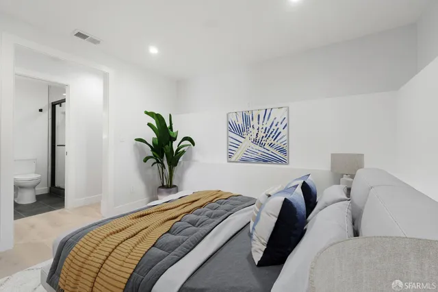 a bedroom with a bed and a potted plant