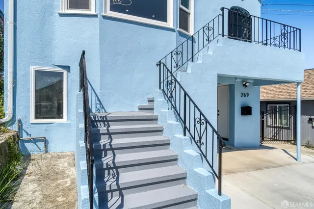 a view of staircase with lots of frames on wall and a large window