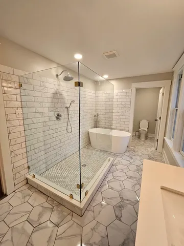 a bathroom with a granite countertop sink a mirror and shower