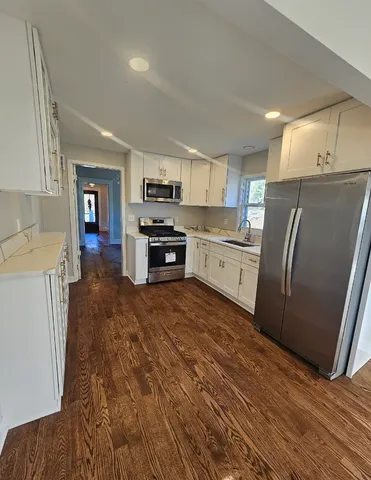 a kitchen with granite countertop a refrigerator stove and sink