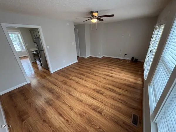a view of empty room with wooden floor