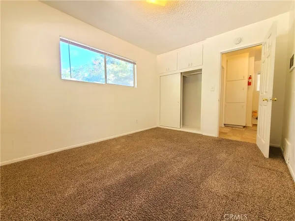 an empty room with windows and closet