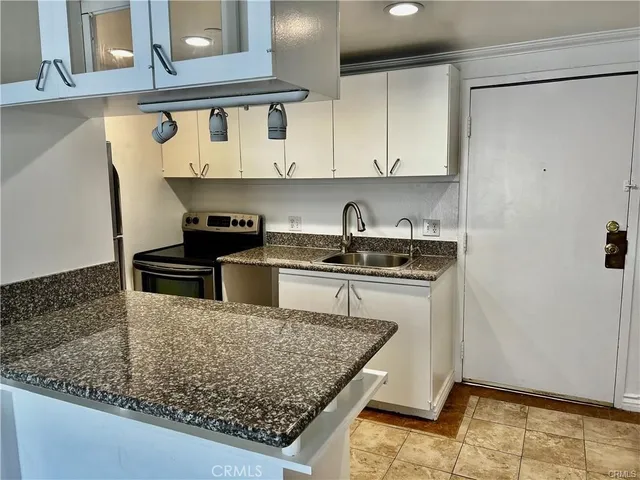 a kitchen with stainless steel appliances granite countertop a sink stove and cabinets