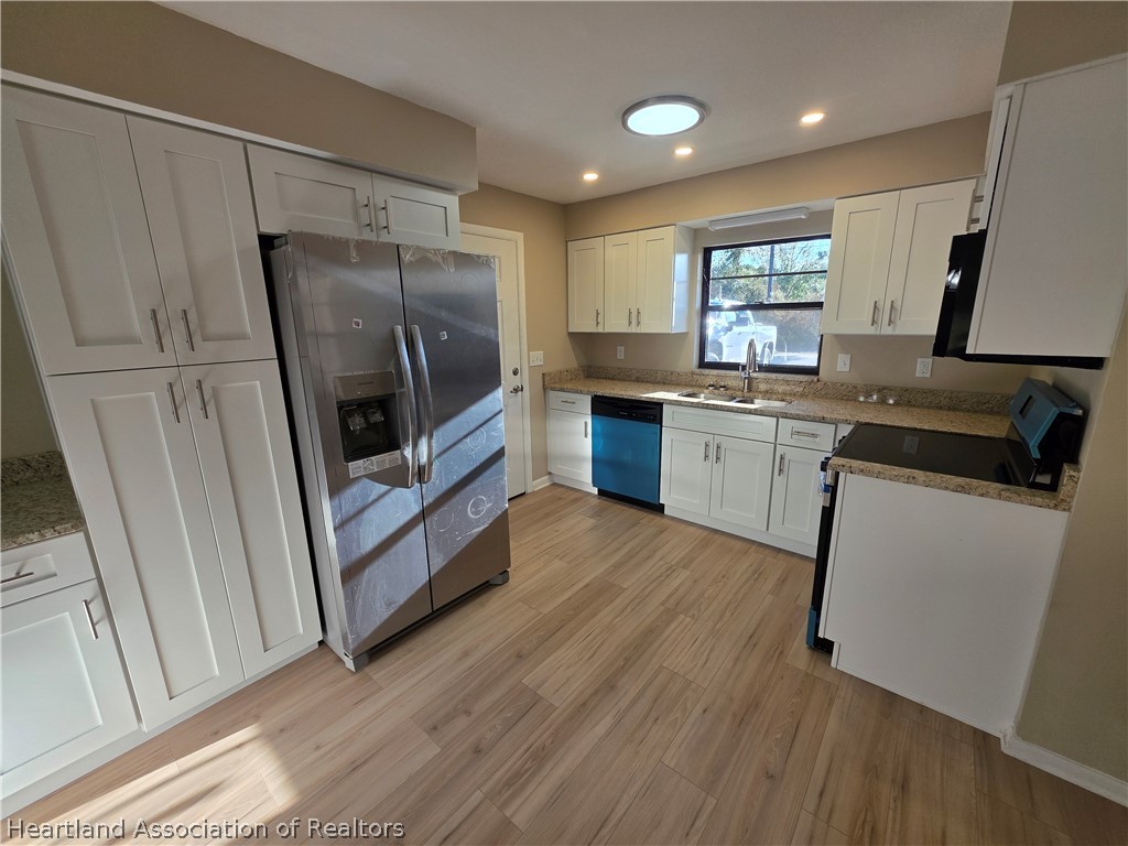 2858 North Lancaster Road Avon Park, FL 33825 - Photo 3 of 13 a kitchen with sink a microwave a refrigerator and wooden floor
