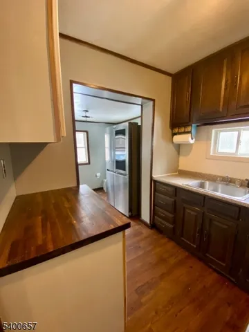 a kitchen with sink a refrigerator and wooden cabinets