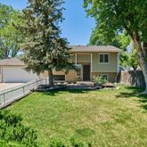 a view of a house with backyard and sitting area