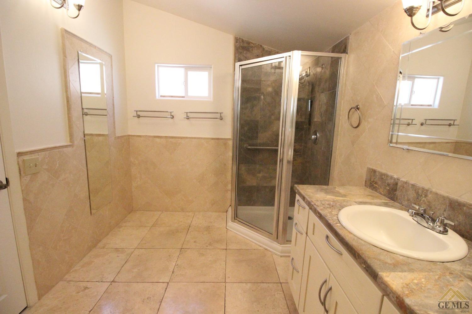 Undisclosed Address Bakersfield, CA 93308 - Photo 20 of 26 a bathroom with a granite countertop shower a sink and a mirror
