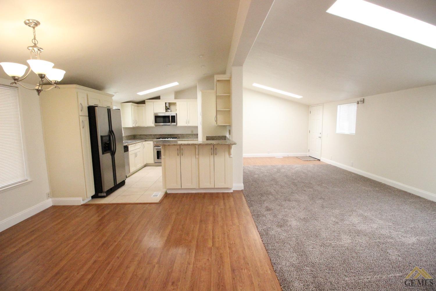 Undisclosed Address Bakersfield, CA 93308 - Photo 8 of 26 a view of a kitchen with wooden floor and a refrigerator