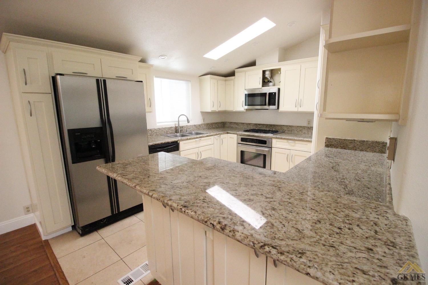 Undisclosed Address Bakersfield, CA 93308 - Photo 10 of 26 a kitchen with granite countertop a refrigerator stove and sink