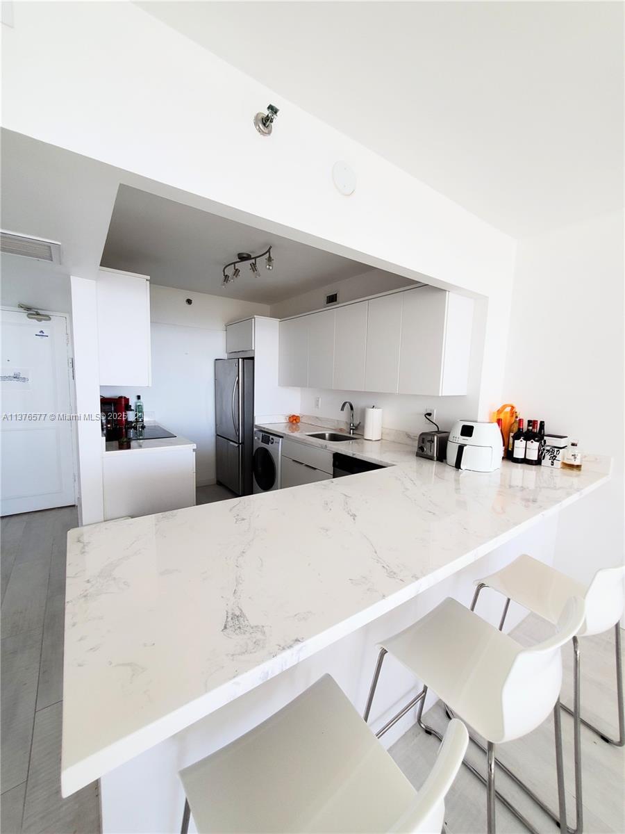100 Lincoln Road, Unit 1244 Miami Beach, FL 33139 - Photo 19 of 68 a kitchen with stainless steel appliances a refrigerator and a sink