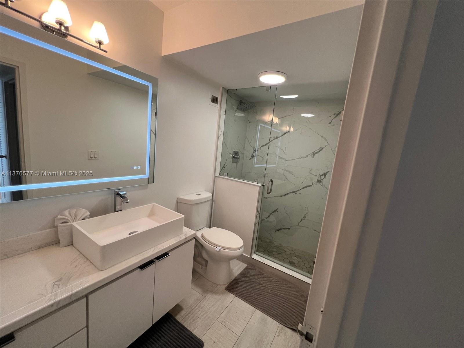 100 Lincoln Road, Unit 1244 Miami Beach, FL 33139 - Photo 25 of 68 a bathroom with a sink a toilet a mirror and shower