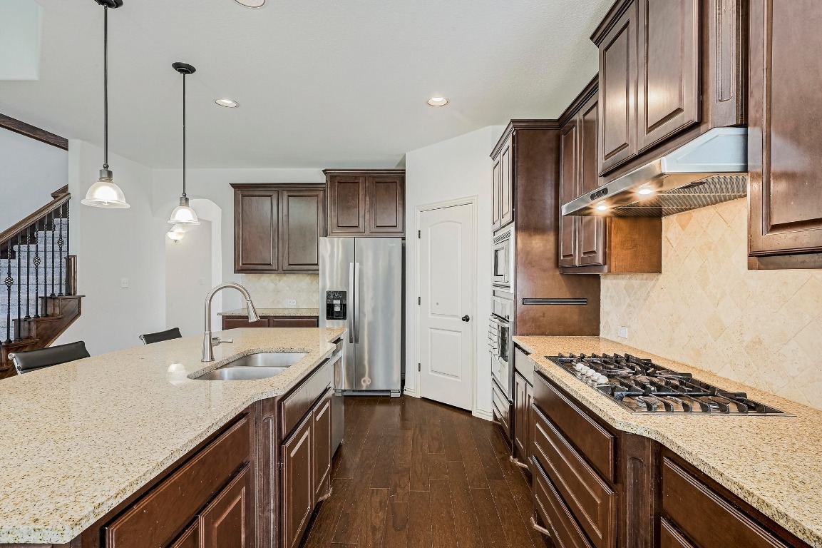 2229 Turtle Mountain Bend Austin, TX 78748 - Photo 12 of 38 a kitchen with stainless steel appliances granite countertop a sink stove and refrigerator