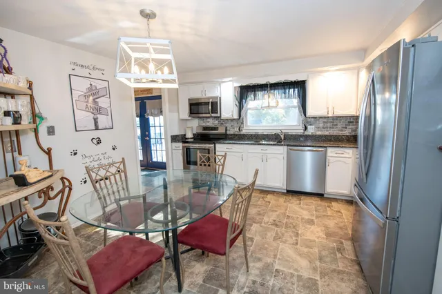 a kitchen with stainless steel appliances granite countertop a stove top oven a sink dishwasher and a refrigerator