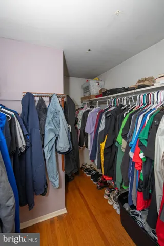 a view of walk in closet with clothes and shoes