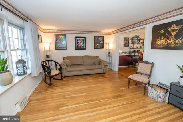 a living room with furniture and a painting on the wall