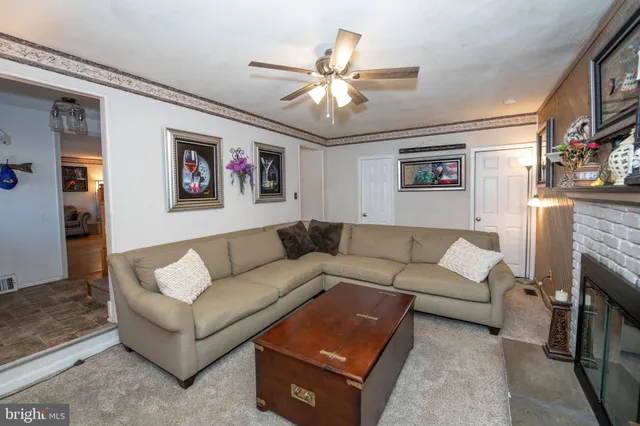 a living room with furniture and a ceiling fan