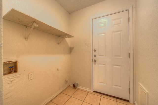 6906 Deep Circle, Unit B Austin, TX 78744 - Photo 14 of 19 Laundry room with a textured ceiling, light tile patterned flooring, washer hookup, and a textured wall