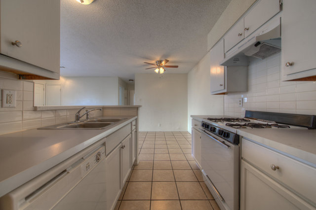 6906 Deep Circle, Unit B Austin, TX 78744 - Photo 15 of 19 Kitchen featuring gas range oven, tasteful backsplash, white dishwasher, light countertops, and ceiling fan